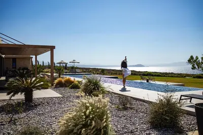 a woman standing on a walkway near a swimming pool at Kiyomi Villa in Chania Town