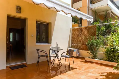 a patio with chairs and a table in a building at Laurels Apartment in Chania Town