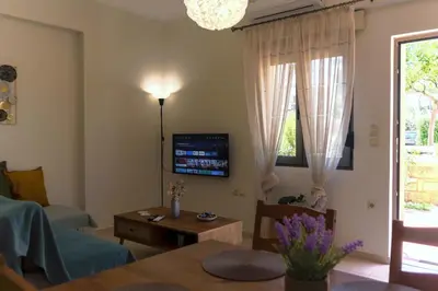 a living room with a tv and a table at Laurels Apartment in Chania Town