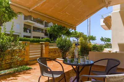 a patio with a table and chairs and a building at Laurels Apartment in Chania Town