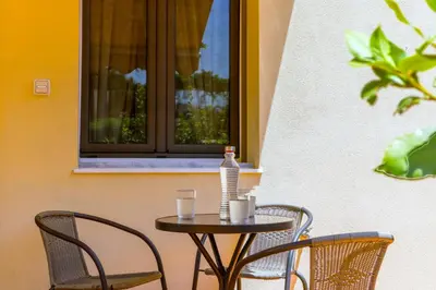 a table with two chairs and a bottle of water on it at Laurels Apartment in Chania Town