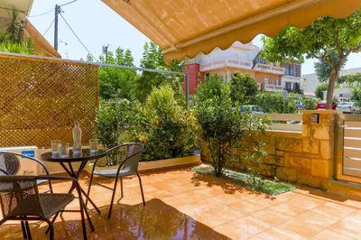 a patio with a table and chairs and a fence at Laurels Apartment in Chania Town