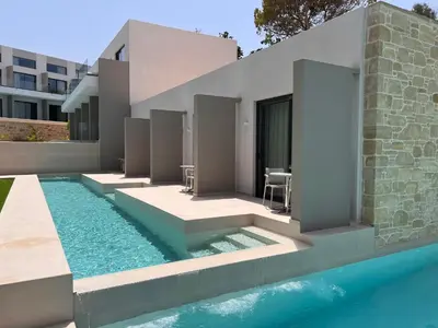 a house with a swimming pool next to a building at Phos Hotel Adults Only in Plataniás