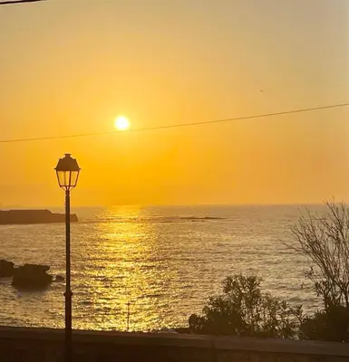 a sunset over the ocean with a street light at NAOS-Sea front vacation rental by Chania center in Chania Town