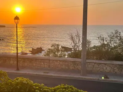 a sunset over the ocean with a street light at NAOS-Sea front vacation rental by Chania center in Chania Town