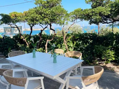 a white table and chairs with a view of the ocean at NAOS-Sea front vacation rental by Chania center in Chania Town