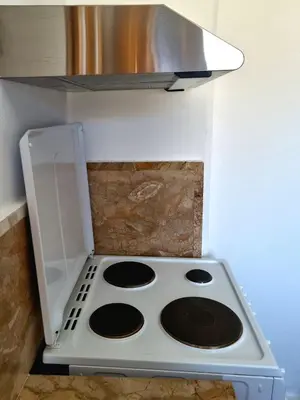 a stove top oven in the corner of a kitchen at All Season Lovely Seafront Cottage in Kissamos