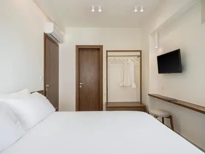 a bedroom with a white bed and a television at Villa Seyian in Chania Town