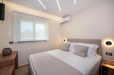 a bedroom with a white bed and a window at Kalopsia Luxury Apartment Near Chania in Chania Town