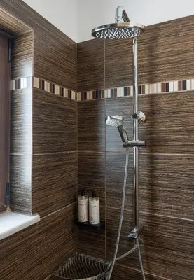 a shower in a bathroom with wooden walls at Villa Wisdom - Elegant & Homely with Pool, Galatas in Chania Town