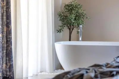 a bathroom with a white tub with a plant in it at Yemaya Sea View Villa in Chania Town
