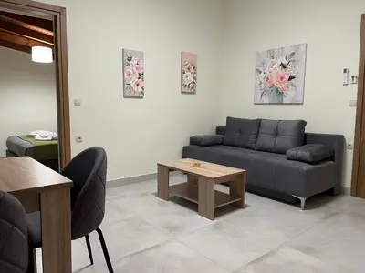 a living room with a couch and a table at GREENHOUSE maleme in Ayiá