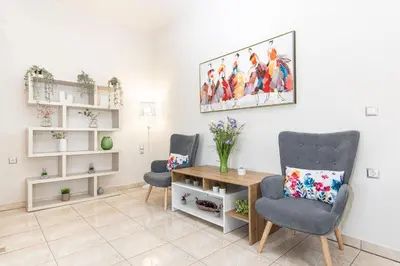 a living room with two chairs and a table at Lumina Apartment with Shared Pool in Perivólia