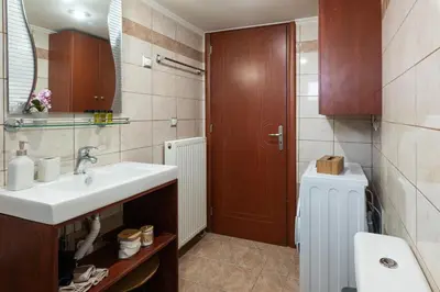 a bathroom with a sink and a mirror at Lumina Apartment with Shared Pool in Perivólia