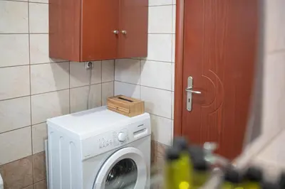 a washing machine with a wooden box on top of it at Lumina Apartment with Shared Pool in Perivólia