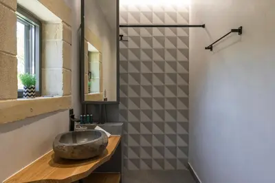 a bathroom with a stone sink and a mirror at Luxury villas Argalios in Drapaniás