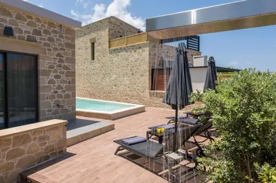 a patio with an umbrella and chairs and a pool at Luxury villas Argalios in Drapaniás