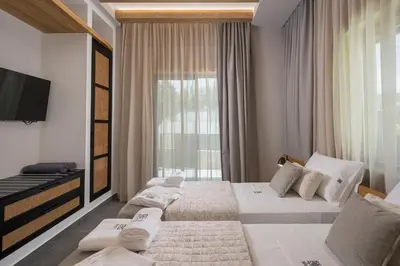a hotel room with two beds and a large window at Luxury villas Argalios in Drapaniás