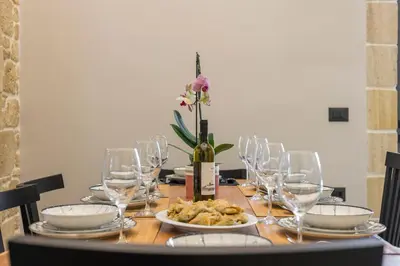 a table with glasses and a bottle of wine and food at Luxury villas Argalios in Drapaniás