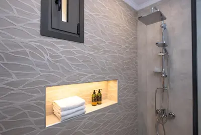 a bathroom with a shelf with towels and wine bottles at Basiliko in Kalidhónia