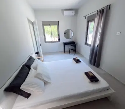 a bedroom with a large white bed with two plates on it at Rodi Apartment in Kolymvari