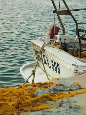 a white boat with a pile of garbage in the water at Rodi Apartment in Kolymvari