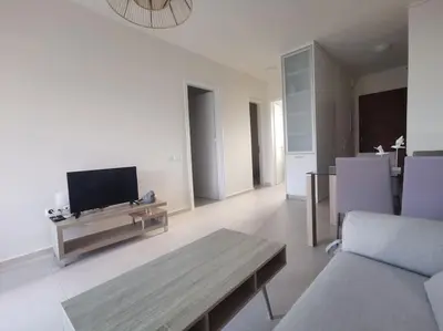 a living room with a tv and a couch and a table at \u4e24\u5367\u5ba4\u516c\u5bd3-\u5e26\u9732\u53f0\u82b1\u56ed in Chania Town