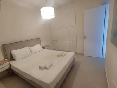 a bedroom with a large white bed with a light at \u4e24\u5367\u5ba4\u516c\u5bd3-\u5e26\u9732\u53f0\u82b1\u56ed in Chania Town