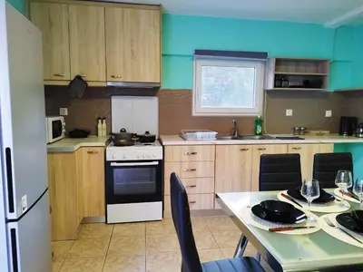 a kitchen with a table and a white stove top oven at SleepiLi in Vrísai