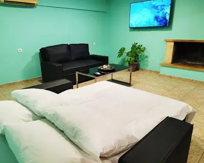 a room with a bed and a couch and a table at SleepiLi in Vrísai