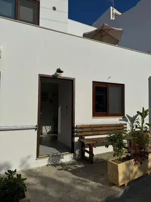 a wooden bench next to a building with a window at Kasteli Apartment in Kissamos