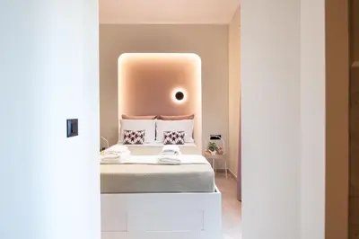 a bedroom with a bed with a pink wall at Centrale Apartment Chania in Chania Town