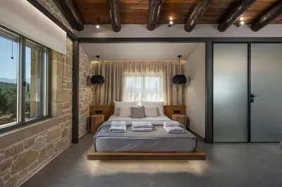 a bedroom with a large bed in a brick wall at Semes luxury villas in Drapaniás