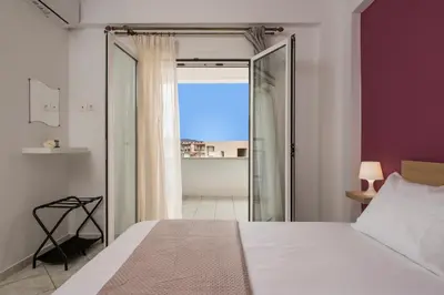 a bedroom with a bed and a view of the ocean at Maison Evelyn in Tsikalariá