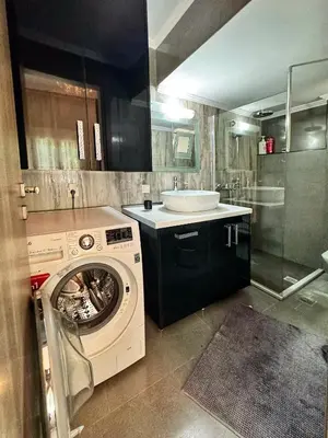 a bathroom with a washing machine and a sink at Lia cozy apartment in Chania Town