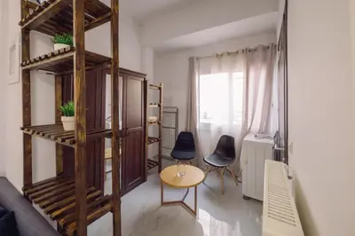 a living room with a wooden shelf and a table and chairs at Koumbes home in Chania Town