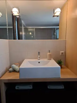 a bathroom with a white sink and a mirror at UPapartment in Chania Town