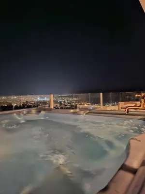 a hot tub with a view of a city at night at UPapartment in Chania Town