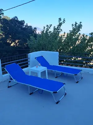 two blue benches sitting on top of a roof at Agnanti in AsfendhilÃ©s