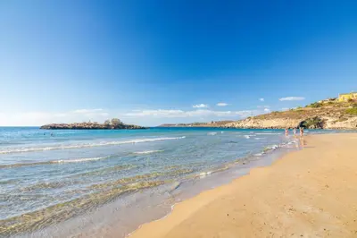 a group of people walking on a beach at PhySea Villa in Kalathas
