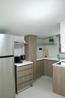 a kitchen with wooden cabinets and a refrigerator at Welcome U in Gerani Chanion