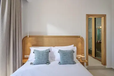 a bedroom with a bed with two blue pillows at Mantis' House in Chania Town