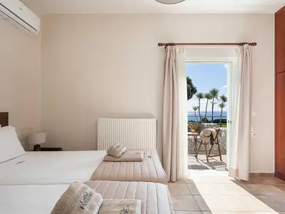 a bedroom with a bed and a view of the ocean at Casa Horizon in Palaiochóra