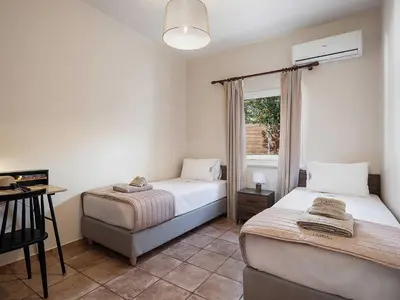 a bedroom with two beds and a window at Casa Horizon in Palaiochóra