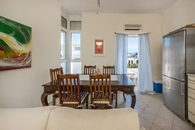 a kitchen and dining room with a table and chairs at Kaloudis Apartment in Kissamos