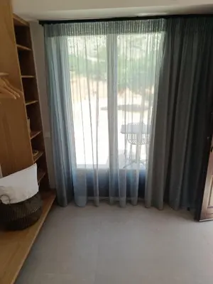 a room with a window with blue curtains at Talos in Sougia
