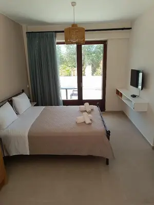 a bedroom with a bed with a teddy bear on it at Talos in Sougia