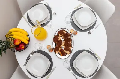 a white table with a plate of food and fruit at GOZA Cozy house in Chania Town