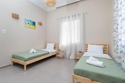 two beds in a room with white walls at GOZA Cozy house in Chania Town