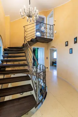 a spiral staircase in a living room with a chandelier at Villa Sun Rock - Ravdoucha in Kolymvari